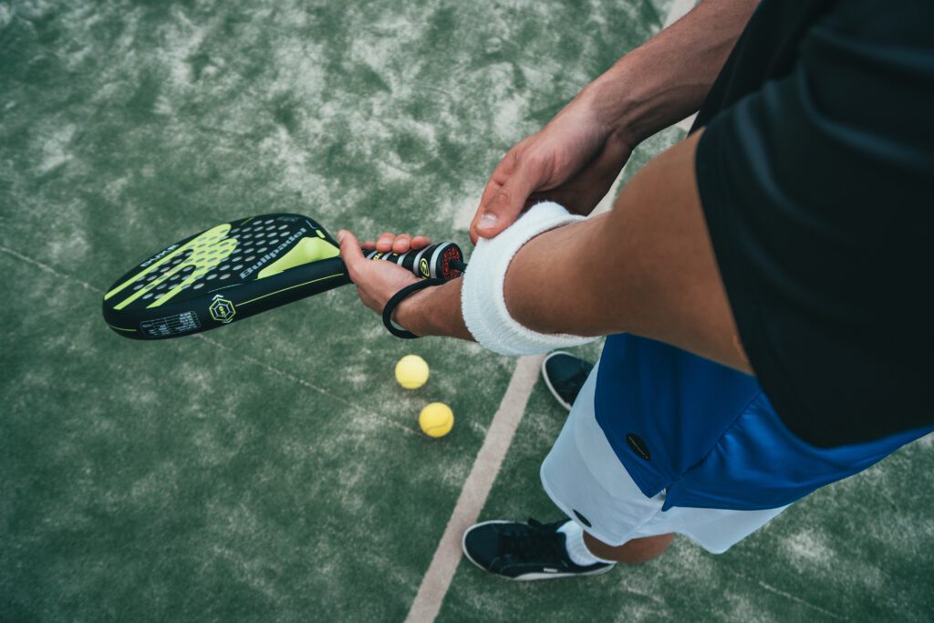 Een man houdt een ecologisch tennisracket vast op een tennisbaan.